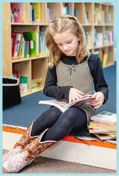 Child framed.png A photograph of a child reading a book in the library.