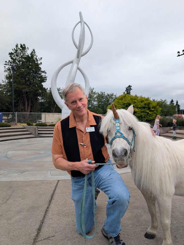 Jeff Weiss and Pyxis.jpg A photo of human being Jeff Weiss kneeling next to Pyxis the Unicorn.
