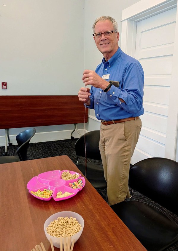Jeff Weiss at Play Lab.jpg A photo of Jeff stringing cereal on some string and smiling at the camera.